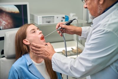 Medical professional carefully examines the patients throat using a specialized medical tool in a clinic setting